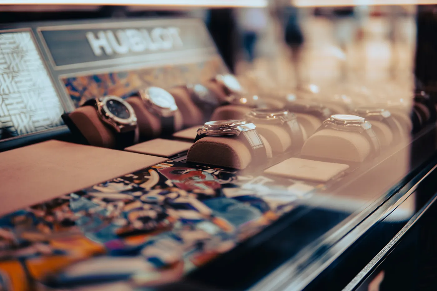 Luxury watches displayed on cushions under glass in a boutique showcase