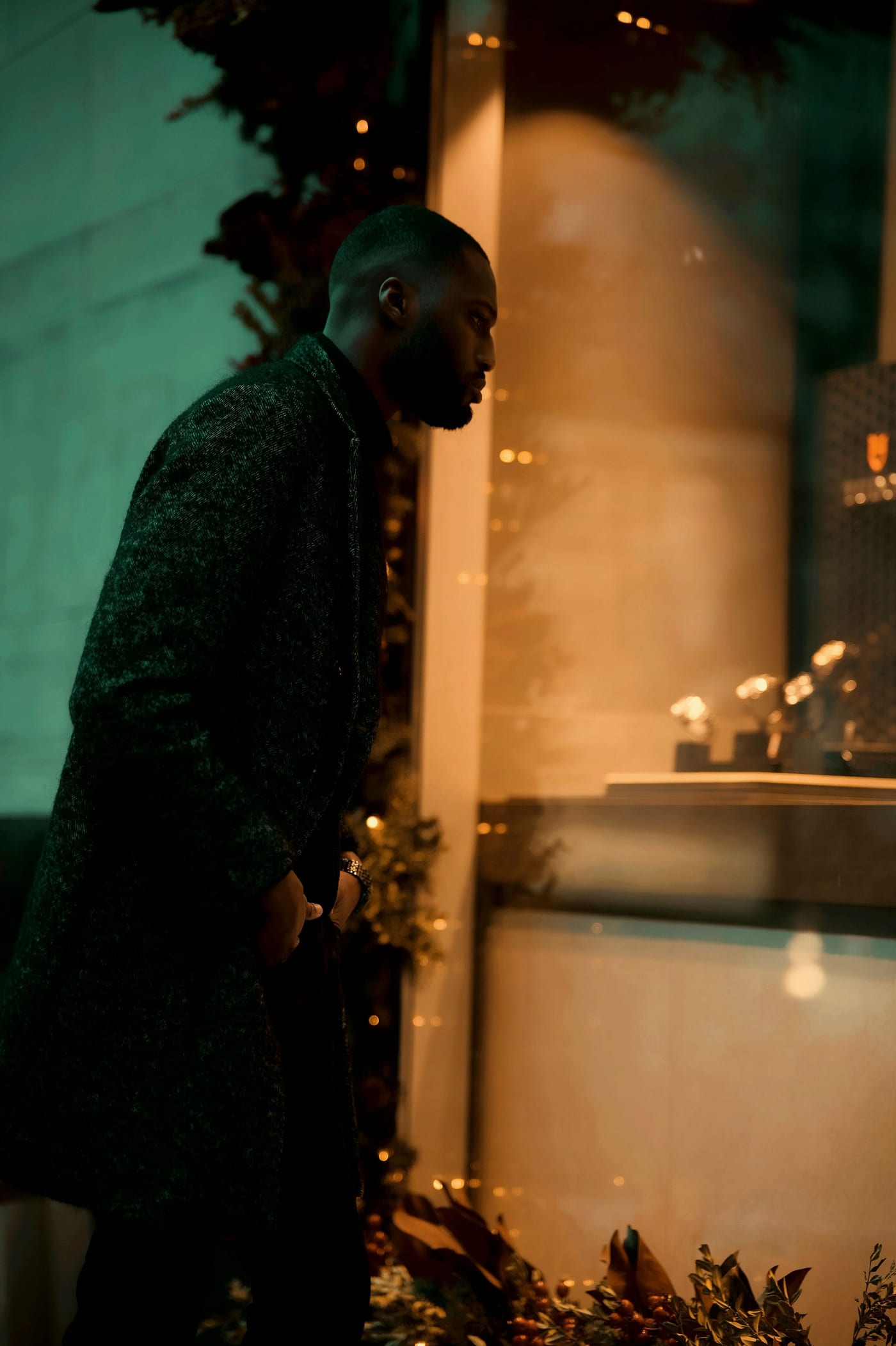 A collector drawn to a warmly lit luxury watch boutique window at night