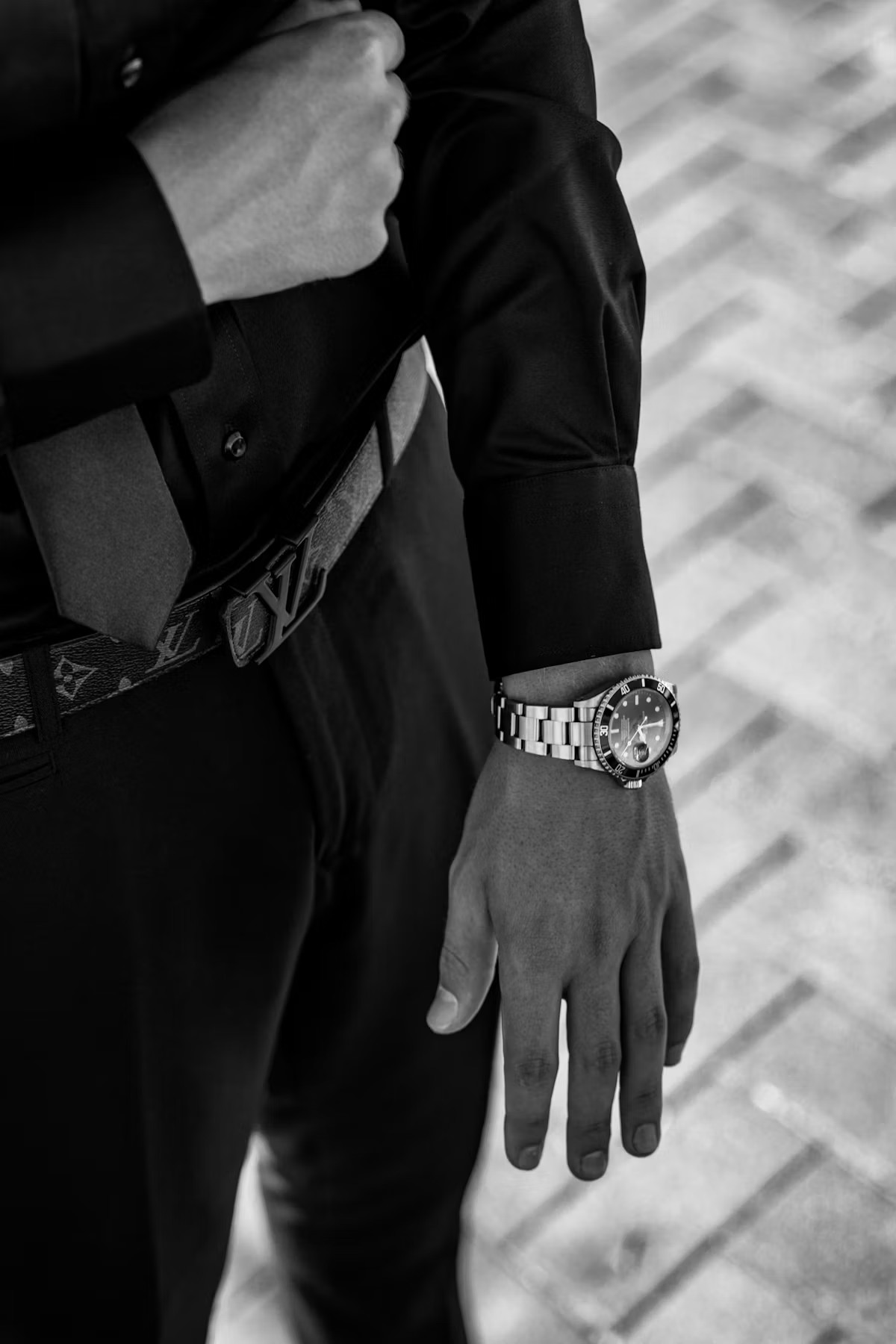 A Rolex Submariner with black dive bezel and Mercedes hands worn on the wrist with tailored menswear